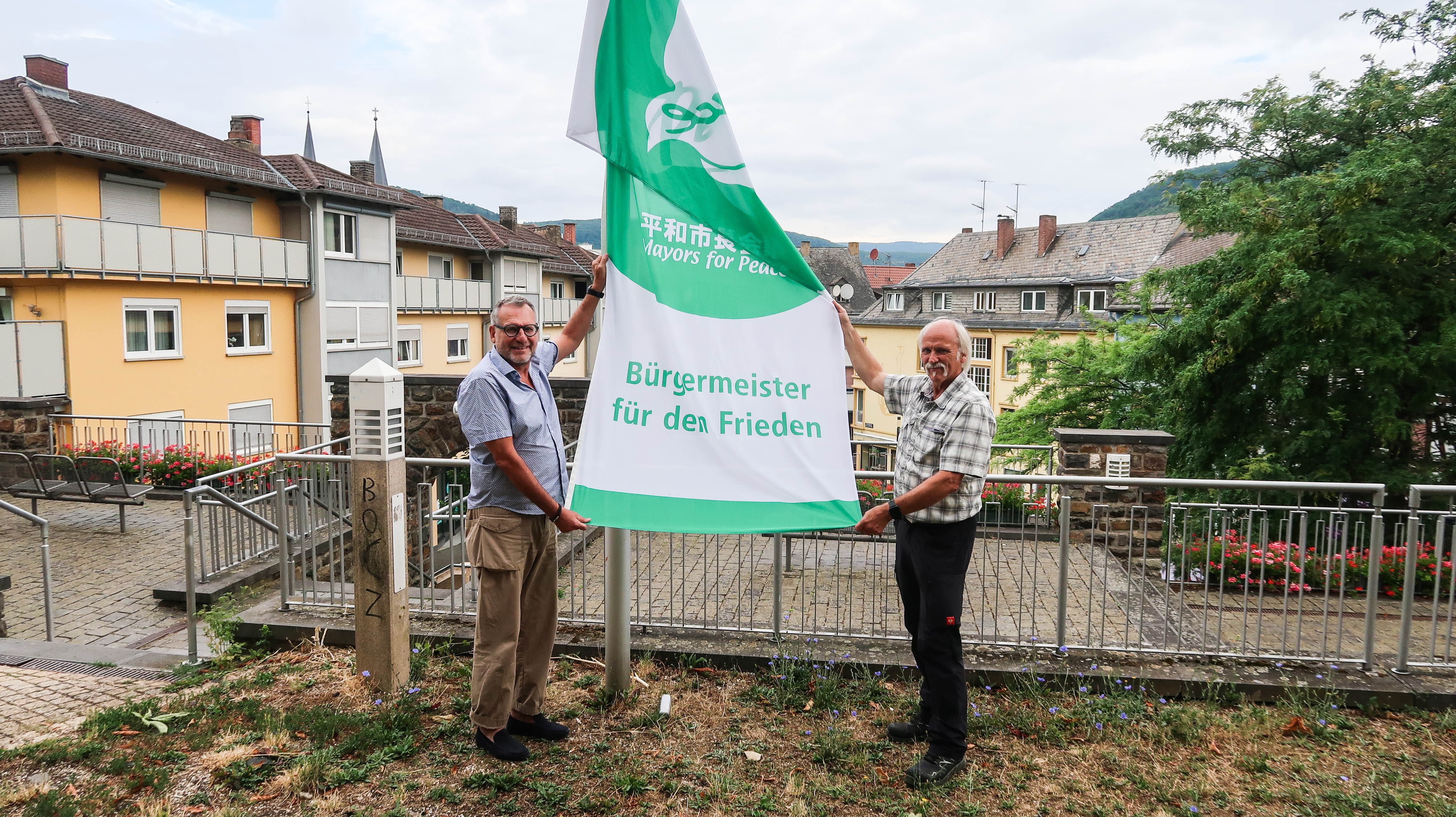 Oberbürgermeister Thomas Feser (li.) und Peter Heyn, Leiter der Abteilung Bauhof  des städtischen Servicebetriebs, beim Hissen der Flagge für den Frieden am 8. Juli.