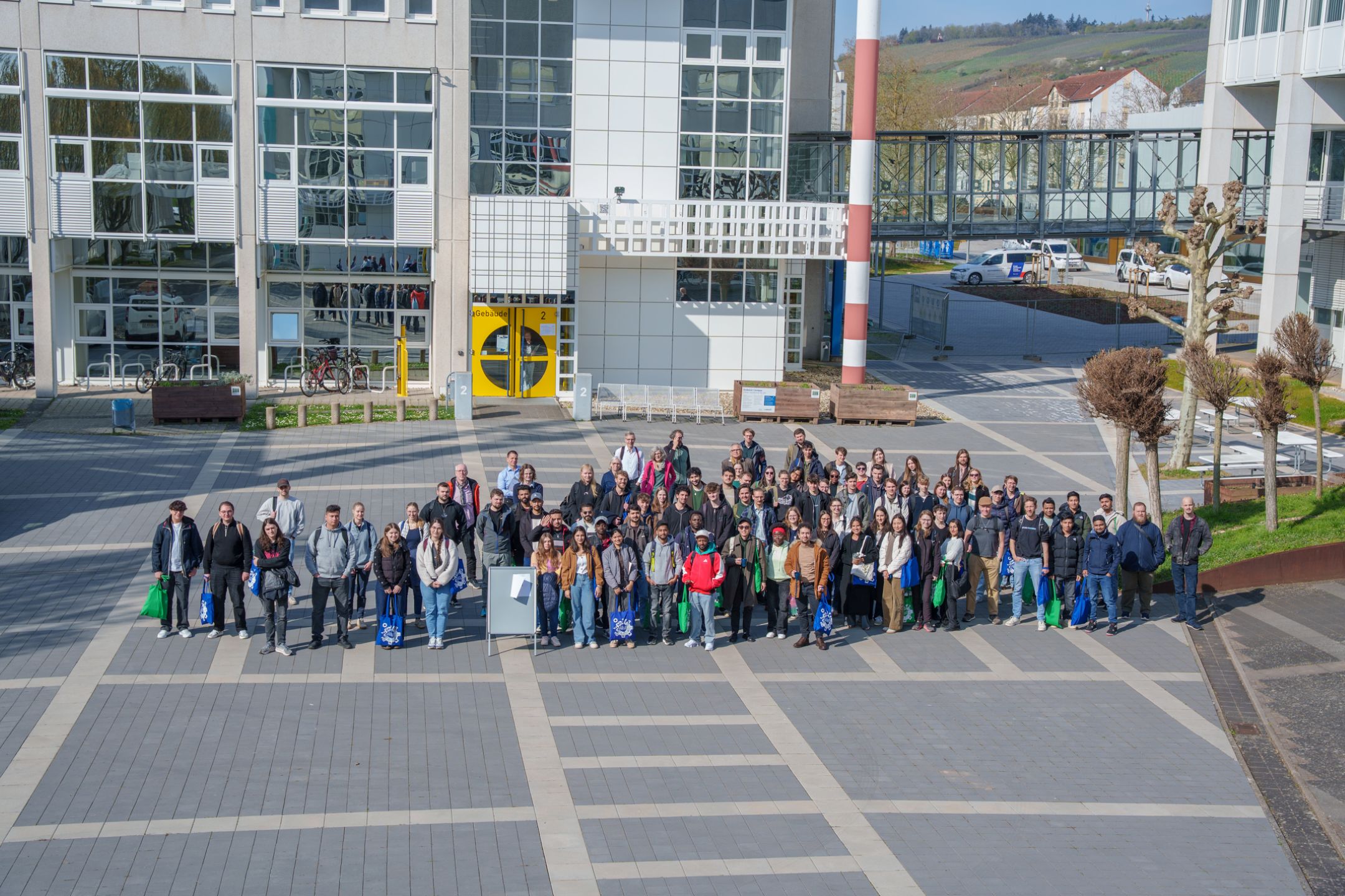 Die Erstsemesterstudierenden versammeln sich zum gemeinsamen Foto im Innenhof des Campus.