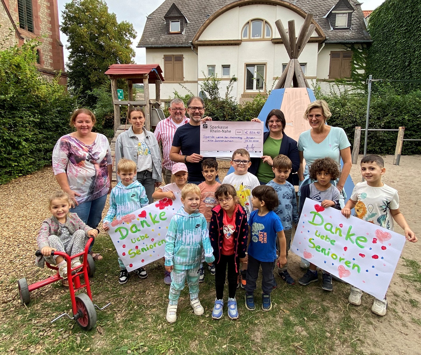 Freude bei der Scheckübergabe: Kinder der Kita Sonnenschein, Beigeordneter Sebastian Hamann, Amtsleiter Ralf Klingler, Alexandra Decker (Abteilungsleiterin Kitas) und Moderatorin Nicole Kierdorf, die durch den Nachmittag führte, bedanken sich herzlich.