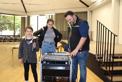 Emilia Böhm aus Dorsheim (li.) und Tereza Vancheva aus Bingen mit Hausmeister Sebastian Hoff beim Technik-Check im Kulturzentrum.