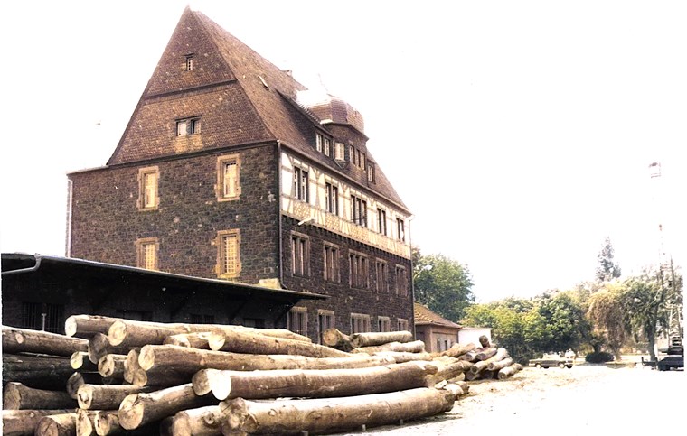 Das Foto wurde 1976 aufgenommen und zeigt das Zollamt mit abgelagerten Baumstämmen.