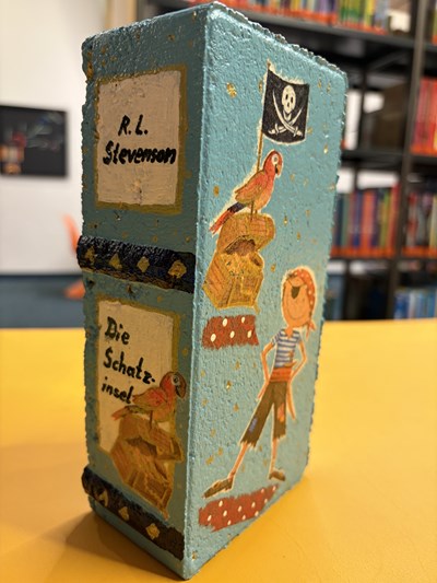 In diesem Jahr können alle Kinder auch kreative Beiträge, wie beispielsweise diesen bunt gestalteten Stein, zum gelesenen Buch abgeben.