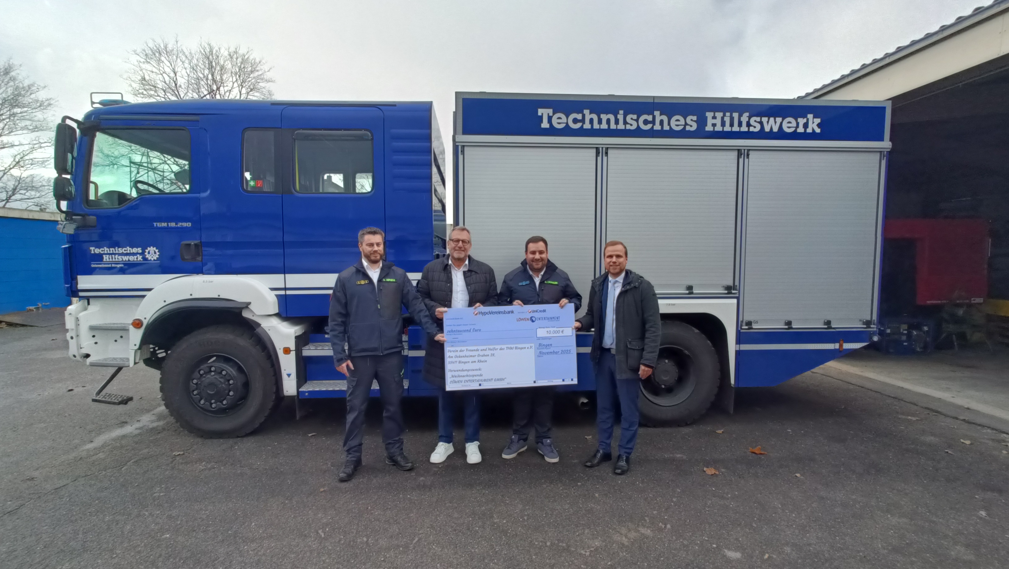 (v.l.n.r.) Simon Herzog (THW), Oberbürgermeister Thomas Feser, Alexander Cronauer (THW) und Sebastian Foethke (LÖWEN ENTERTAINMENT) bei der symbolischen Scheckübergabe auf dem THW-Gelände in Kempten