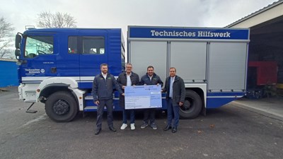 (v.l.n.r.) Simon Herzog (THW), Oberbürgermeister Thomas Feser, Alexander Cronauer (THW) und Sebastian Foethke (LÖWEN ENTERTAINMENT) bei der symbolischen Scheckübergabe auf dem THW-Gelände in Kempten
