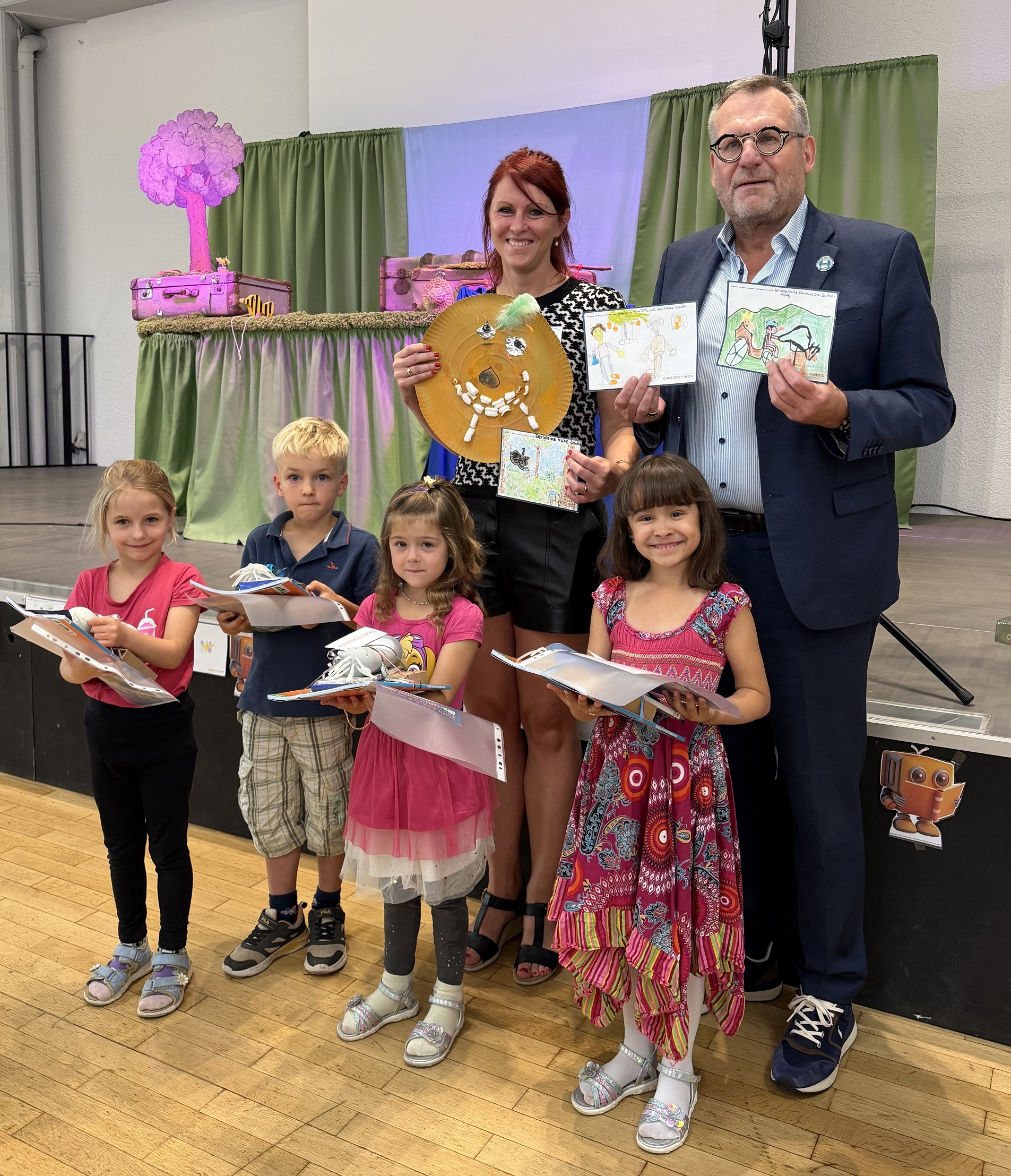 Oberbürgermeister Thomas Feser und Büchereileiterin Julia Löffler gratulieren den kleinen Künstlerinnen und dem kleinen Künstler, die die schönsten Bilder zum Vorlesesommer gemalt haben.