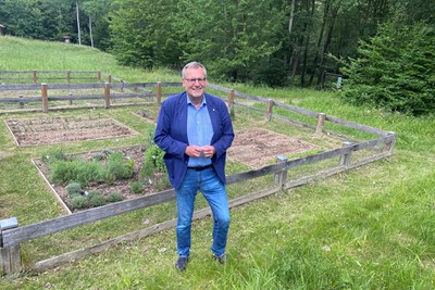 Oberbürgermeister Thomas Feser präsentiert das Kooperationsprojekt ‚Biotoppflege‘, das ge-meinsam mit der Caritas gestartet ist. Im Hintergrund ist der „spätantike“ Nutzgarten an der Villa Rustica im Binger Wald zu sehen