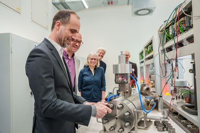 Minister Clemens Hoch (links) unter der fachkundigen Anleitung von Prof. Dr.-Ing. habil. Herbert Baaser (2.v.l.) am Wasserstoff-Prüfstand in Aktion.