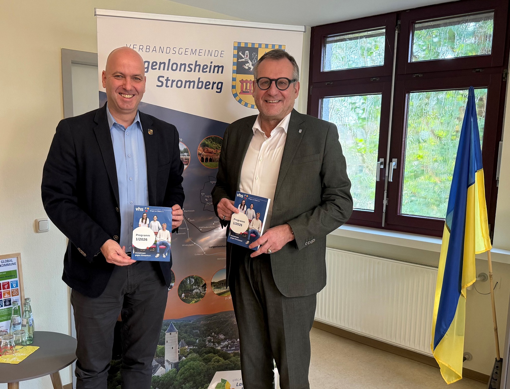 Michael Cyfka, Bürgermeister der VG Langenlonsheim-Stromberg (li.) und Oberbürgermeister der Stadt Bingen Thomas Feser mit dem aktuellen vhs-Programm.