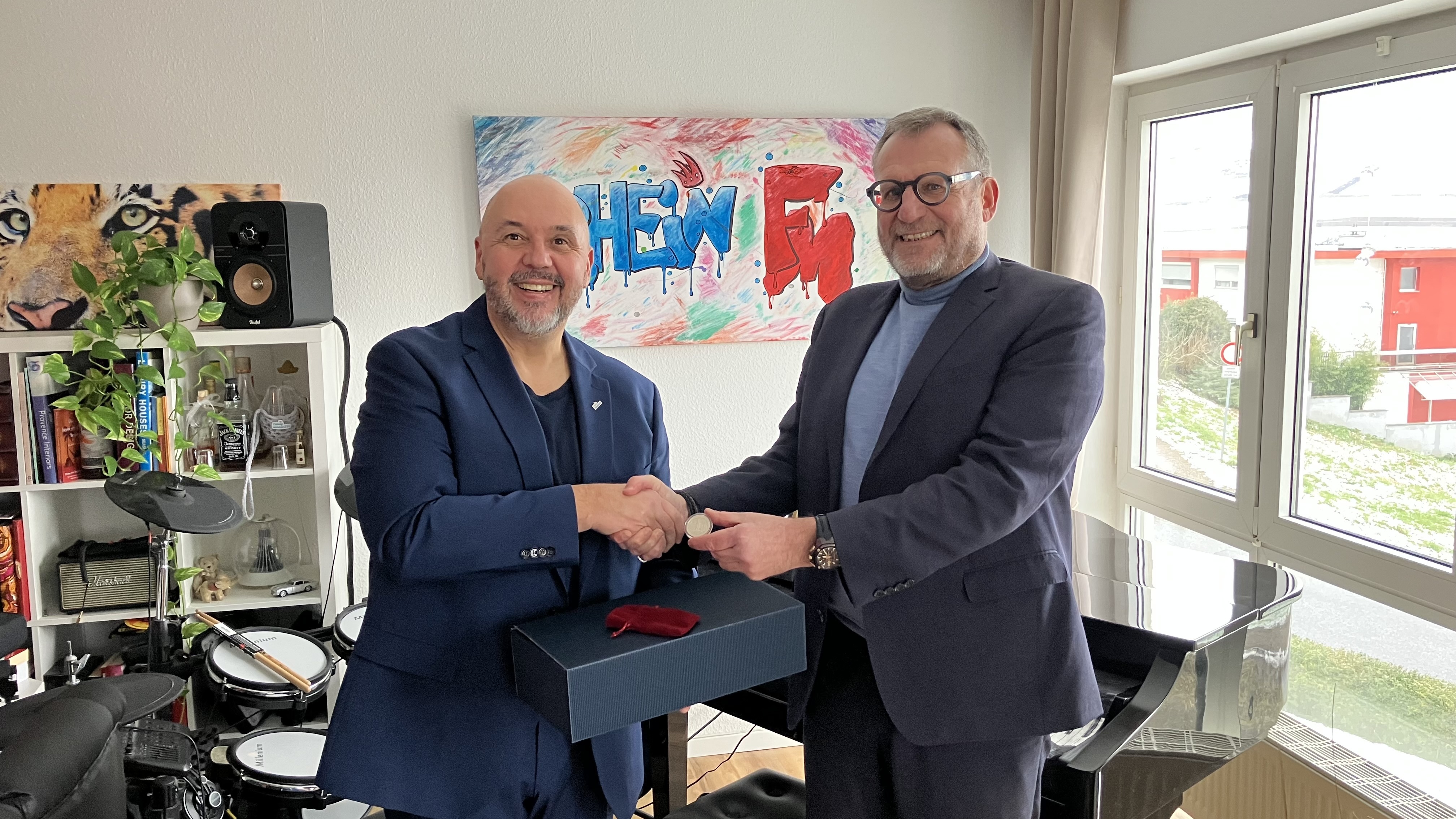 Bildunterschrift: Oberbürgermeister Thomas Feser (rechts im Bild) gratuliert Artur Frank zu 5 Jahren Radio RheinFM. Neben einem Weinpräsent überreichte das Stadtoberhaupt auch den „Binger Rheintaler“ als Zeichen der Anerkennung.