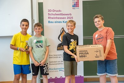 Das Siegerteam „Die vier Wölfe“ präsentiert stolz die Siegtrophäe und den 3D-Drucker.
