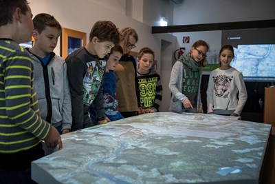 Schülerinnen und Schüler untersuchen ein 3D-Modell des Oberen Mittelrheintals im Stellwerk