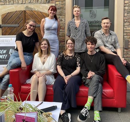 Die Teilnehmerinnen und Teilnehmer des Poetry Slam (v. li.): Gewinnerin Verena Hülsbömer, Büchereileiterin Julia Löffler, Mari Dlugosch, Doro von der Loreley, Moderator Leander Bauer, Lennart Hein und Tim Kuppler.