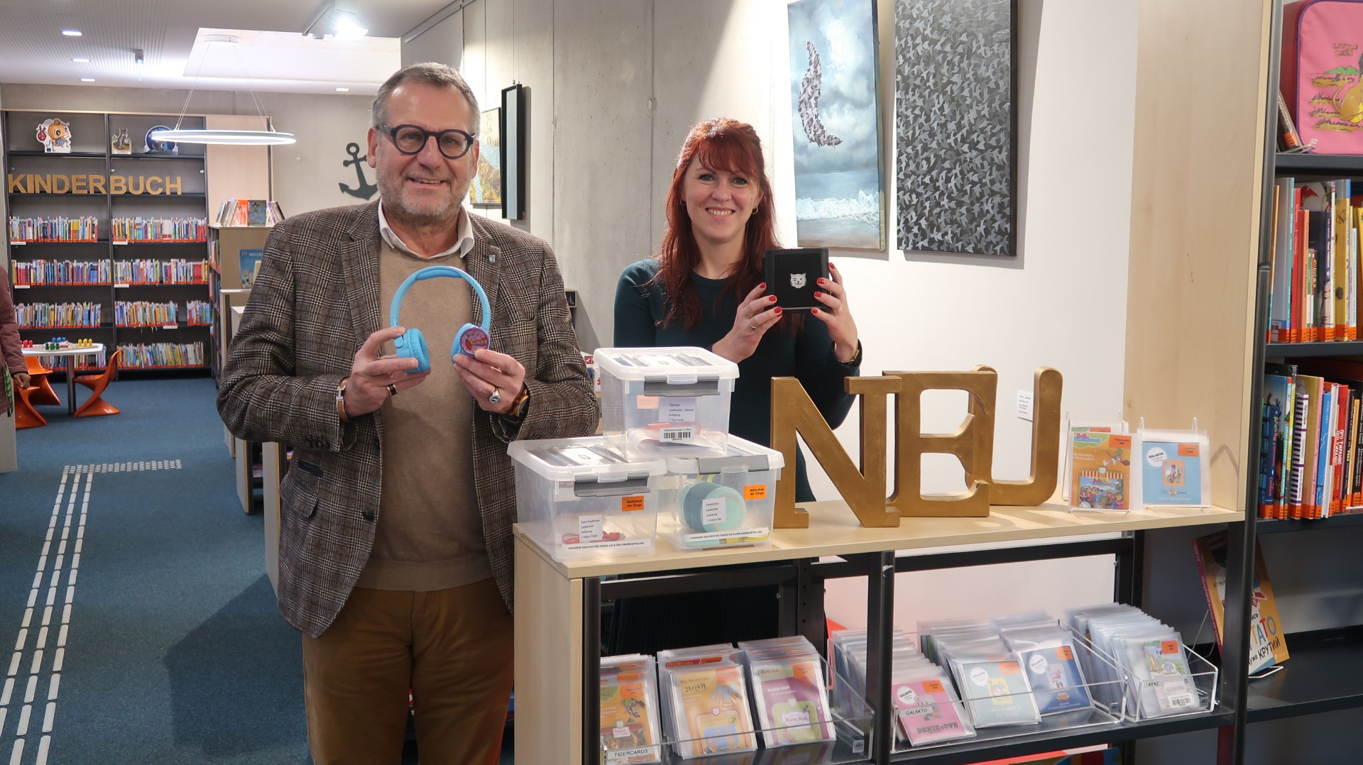 Oberbürgermeister Thomas Feser und Büchereileiterin Julia Löffler präsentieren die neuen Medienformate für Kinder.