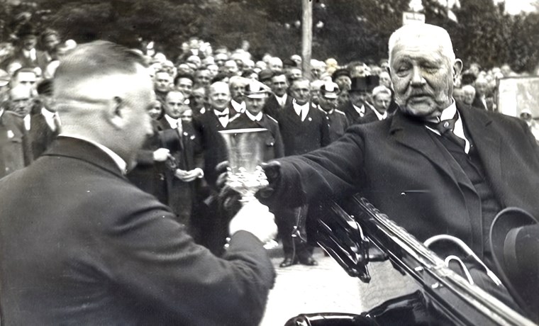 Bürgermeister Dr. Sieglitz reicht als Willkommenstrunk eine 1921er Beerenauslese Scharlachberg